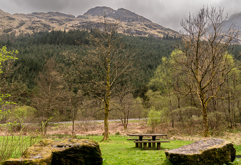 picnic table next to the road with mountains behind