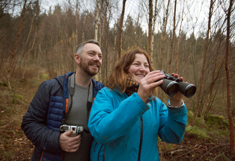 A man and woman with a set of binoculars