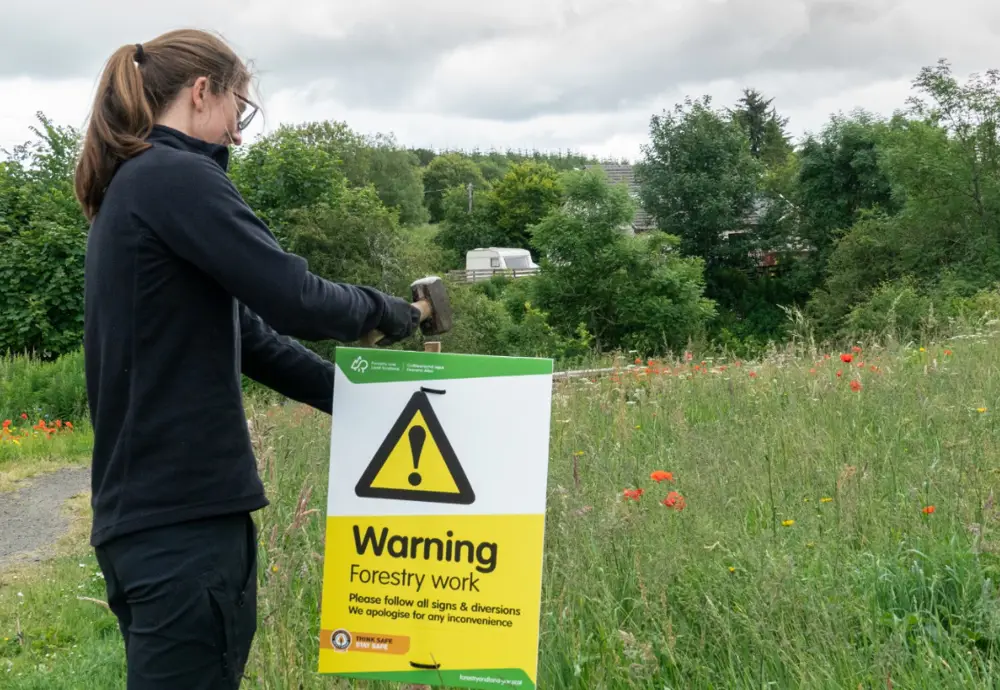staff member putting up a safety sign