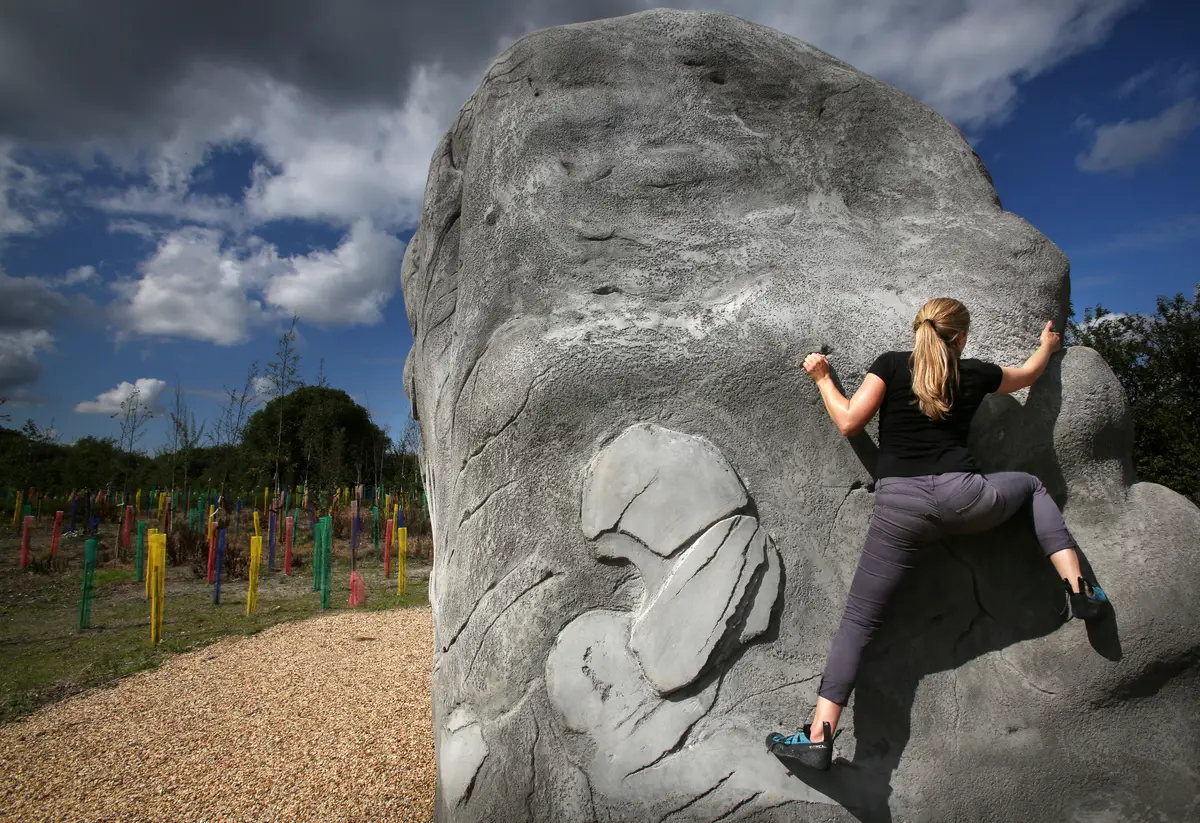 Woman climbing on boulder