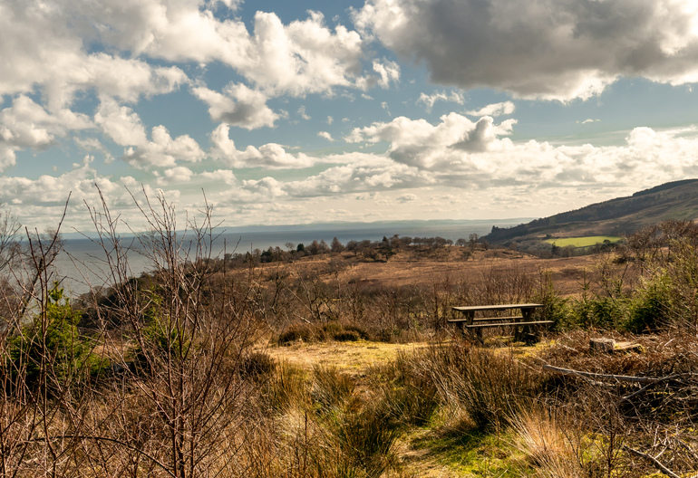 A picnic table on a hillside overlooking the sea